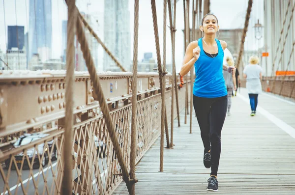 Mujer corriendo en el puente de Brooklyn — Foto de Stock