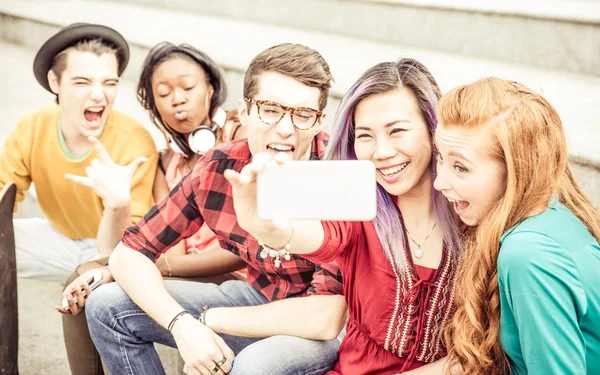 Group of teenagers sitting on the stairs and taking selfie — Stock Photo, Image