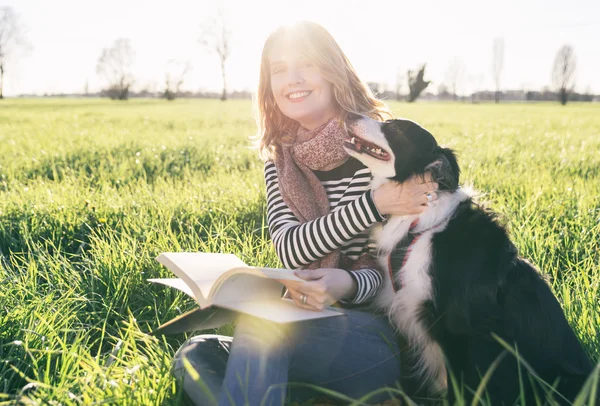 Leende dam tar med sin hund — Stockfoto