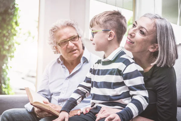 Grandparents spending time with grandson. reading him story in t — Stock Photo, Image