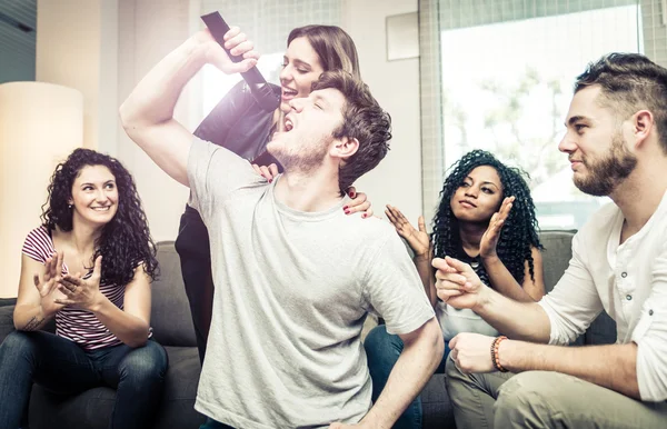 Skupina přátel hrát tvrdě s videohrami a karaoke — Stock fotografie