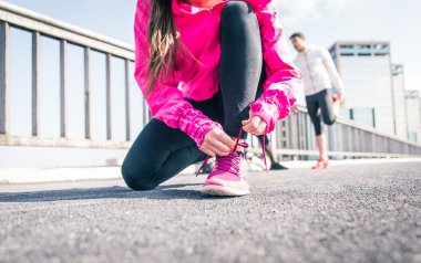 Woman urban runner tying the shoelace up clipart