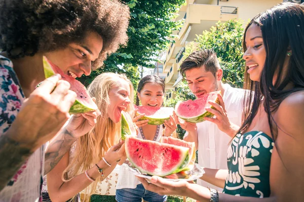 Grupo de amigos comendo melancia no jardim — Fotografia de Stock