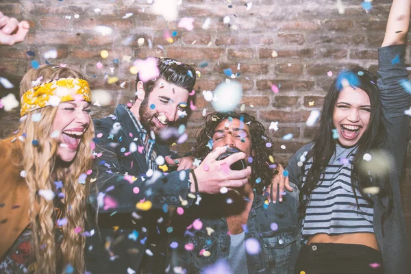 Amigos jogando confete e bebendo champanhe — Fotografia de Stock