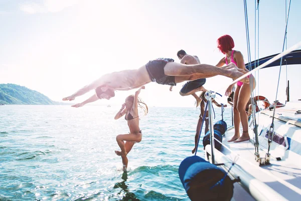 Freunde tauchen bei Bootsausflug ins Wasser — Stockfoto