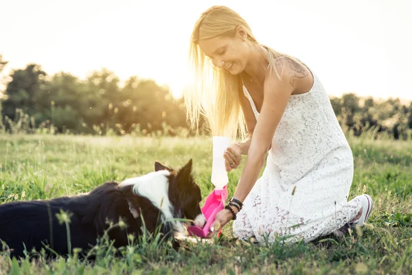 Mulher loira brincando com border collie — Fotografia de Stock