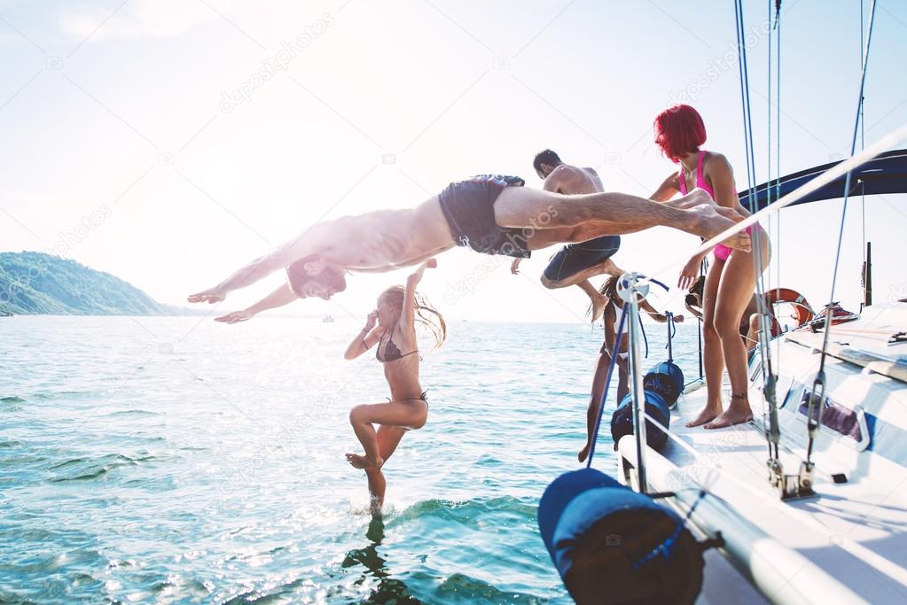 Friends diving in water during boat excursion