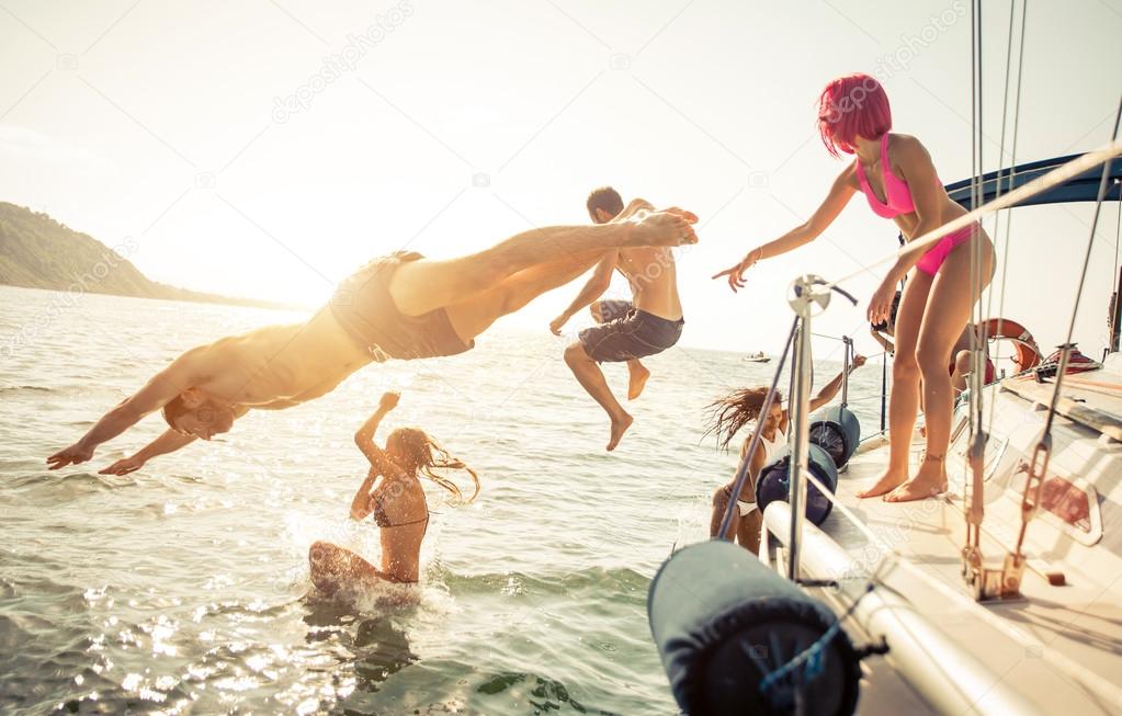 Friends diving in water during boat excursion