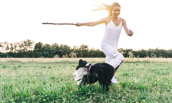 Femme blonde jouant avec la frontière collie — Photo