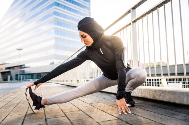 Dışarıda formda vücut eğitimi alan Müslüman sporcu kız - tesettürlü güzel kadın spor egzersizleri yapıyor, sağlık, yaşam tarzı ve işlevsel eğitim hakkında kavramlar yapıyor