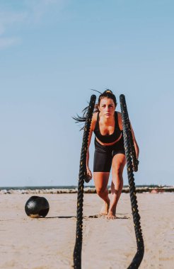 Sahilde egzersiz, spor yapan sağlıklı ve atletik bir kadın - yaşam tarzı, spor ve sağlıklı yaşam tarzı kavramları