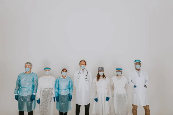 使い捨ての保護スーツを着た医師と看護師のチームとコヴィド コロナウイルス と戦うためのフェイスマスク コロナウイルスのパンデミック隔離中の医療チームの肖像画 医療と医療に関する概念 — ストック写真