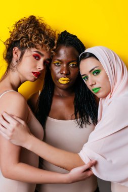 Three girls from different ethnicities posing in studio for a 