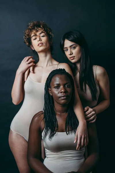 Three girls from different ethnicities posing in studio for a 