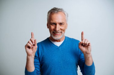 Yakışıklı yaşlı adam gri arka planda izole edilmiş. Üçüncü yaş ve kıdem kavramları