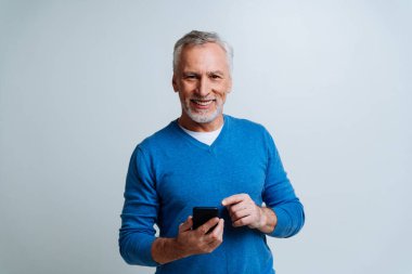 Yakışıklı yaşlı adam gri arka planda izole edilmiş. Üçüncü yaş ve kıdem kavramları