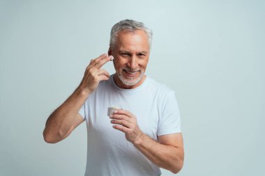 Yakışıklı son sınıf öğrencisi gri arka planda izole edilmiş. Üçüncü yaş ve kıdem kavramları