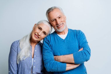 Stüdyoda fotoğraf çekmek için poz veren mutlu yaşlı çift. Yaşam tarzı ve kıdem konsepti