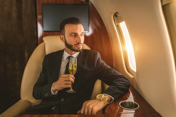 英俊的商人 身穿雅致的西服 乘坐私人专机飞行 成功的企业家 乘坐专机商务舱 商务和贸易概念 — 图库照片