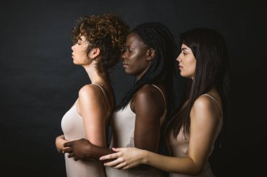 İç çamaşırlarıyla poz veren çok kültürlü kadınlardan oluşan bir grup. 3 güzel kız portresi, çok kültürlü insanlar hakkında kavramlar, kapsayıcı toplum ve beden pozitifliği.