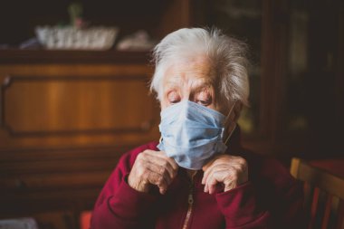 Penceredeki yaşlı kadın portresi. Büyükannem sokağa göz kulak oluyor. 2020 Coronavirus dönemi hakkında 