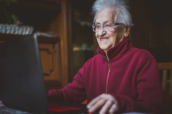 할머니 할머니가 노트북을 사용하고 비디오 채팅을 온라인으로 가족들과 이야기를 나누고 — 스톡 사진