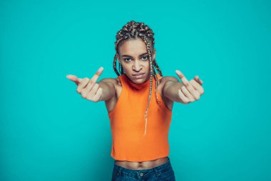 Saçları örgülü güzel bir kız mavi arkaplanda farklı ifadeler takınıyor.