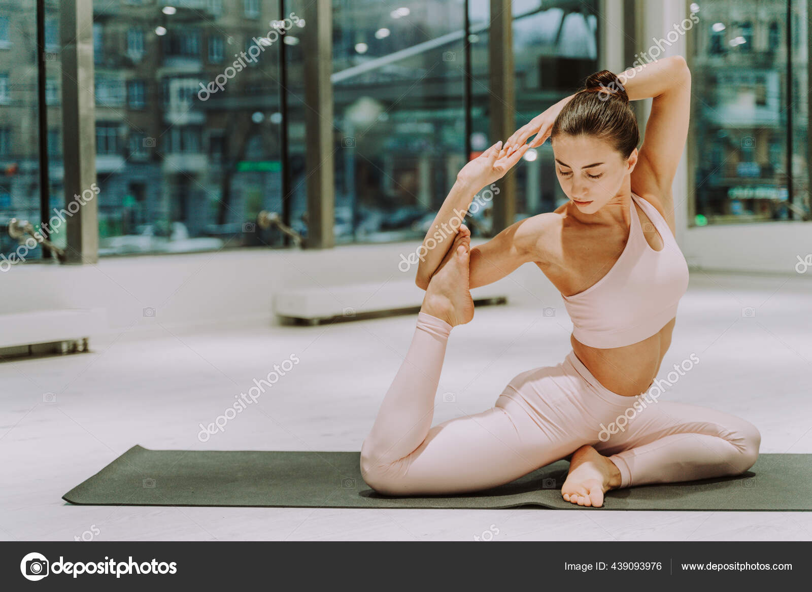 Beautiful athletic woman training in a gym, doing stretching