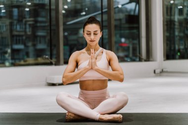 Güzel bir atletik kadın spor salonunda antrenman yapıyor, egzersiz yapmadan önce esneme egzersizleri yapıyor.