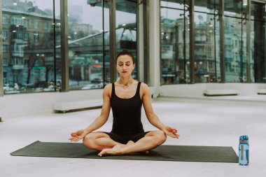 Güzel bir atletik kadın spor salonunda antrenman yapıyor, egzersiz yapmadan önce esneme egzersizleri yapıyor.
