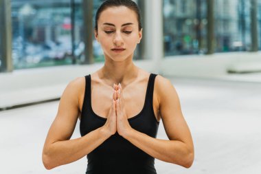 Güzel bir atletik kadın spor salonunda antrenman yapıyor, egzersiz yapmadan önce esneme egzersizleri yapıyor.