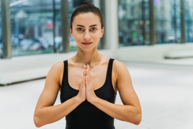 Güzel bir atletik kadın spor salonunda antrenman yapıyor, egzersiz yapmadan önce esneme egzersizleri yapıyor.