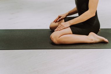 Güzel bir atletik kadın spor salonunda antrenman yapıyor, egzersiz yapmadan önce esneme egzersizleri yapıyor.