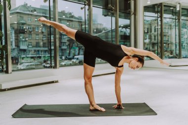 Güzel bir atletik kadın spor salonunda antrenman yapıyor, egzersiz yapmadan önce esneme egzersizleri yapıyor.