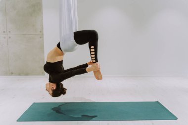 Güzel bir atletik kadın spor salonunda antrenman yapıyor, egzersiz yapmadan önce esneme egzersizleri yapıyor.