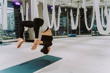Güzel bir atletik kadın spor salonunda antrenman yapıyor, egzersiz yapmadan önce esneme egzersizleri yapıyor.