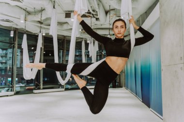 Güzel bir atletik kadın spor salonunda antrenman yapıyor, egzersiz yapmadan önce esneme egzersizleri yapıyor.