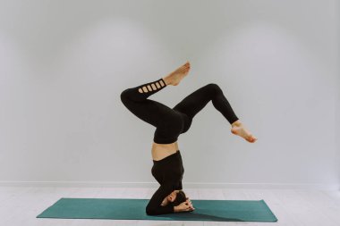 Güzel bir atletik kadın spor salonunda antrenman yapıyor, egzersiz yapmadan önce esneme egzersizleri yapıyor.