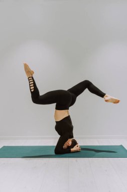 Güzel bir atletik kadın spor salonunda antrenman yapıyor, egzersiz yapmadan önce esneme egzersizleri yapıyor.