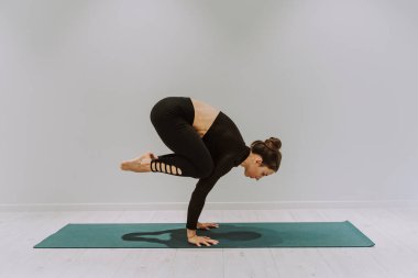 Güzel bir atletik kadın spor salonunda antrenman yapıyor, egzersiz yapmadan önce esneme egzersizleri yapıyor.