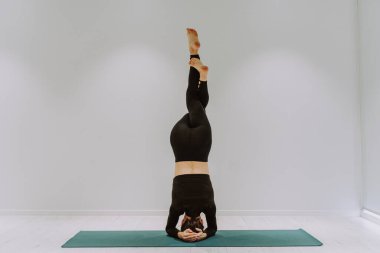 Güzel bir atletik kadın spor salonunda antrenman yapıyor, egzersiz yapmadan önce esneme egzersizleri yapıyor.