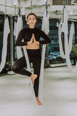 Güzel bir atletik kadın spor salonunda antrenman yapıyor, egzersiz yapmadan önce esneme egzersizleri yapıyor.