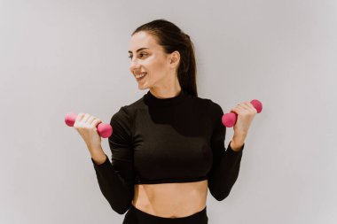 Güzel bir atletik kadın spor salonunda antrenman yapıyor, egzersiz yapmadan önce esneme egzersizleri yapıyor.