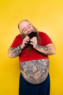 Komik ve komik şişman adam sağlıksız yiyeceğe aç