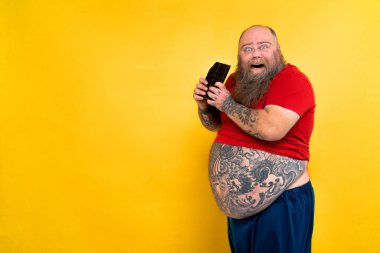 Komik ve komik şişman adam sağlıksız yiyeceğe aç