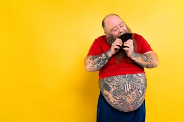 Komik ve komik şişman adam sağlıksız yiyeceğe aç