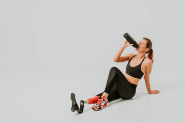 Ampütasyonu olan güzel bir genç kadın - güzel ve kendine güveni tam bir kadın, bacağı sakat, vücudunu mahcup eden bir kadına poz veriyor.