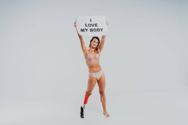 Ampütasyonu olan güzel bir genç kadın - güzel ve kendine güveni tam bir kadın, bacağı sakat, vücudunu mahcup eden bir kadına poz veriyor.