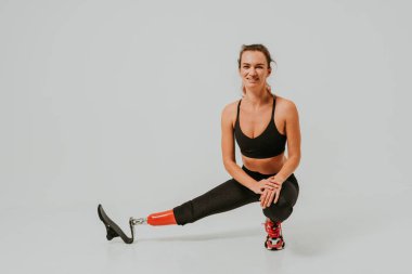 Ampütasyonu olan güzel bir genç kadın - güzel ve kendine güveni tam bir kadın, bacağı sakat, vücudunu mahcup eden bir kadına poz veriyor.