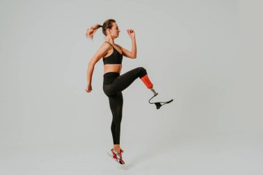 Ampütasyonu olan güzel bir genç kadın - güzel ve kendine güveni tam bir kadın, bacağı sakat, vücudunu mahcup eden bir kadına poz veriyor.